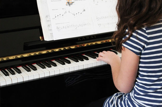 kid playing piano - Are You Buying a Piano? Here’s Our 4 Top Tips for Selecting One That Suits Your Needs and Your Home